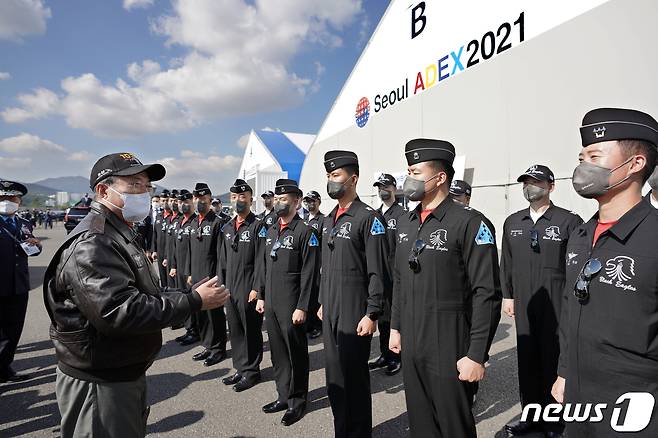 문재인 대통령이 20일 경기도 성남시 서울공항에서 열린 2021 서울 국제 항공우주 및 방위산업 전시회(ADEX) 개막 기념행사에 참석해 시범비행을 마친 공군 특수비행팀 블랙이글스 대원들을 격려하고 있다. 2021.10.20/뉴스1 © News1 이광호 기자