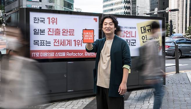 12일 오후, 서울 강남구 강남역에서 강남언니 홍승일 대표가 광고판을 배경으로 포즈를 취하고 있다. / 고운호 기자