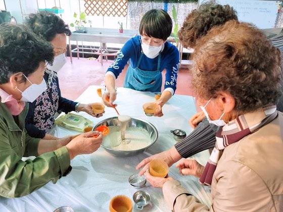 폐암 4기 생존자 전미숙(가운데)씨가 19일 경북 영천 자신의 카페에서 할머니들에게 보리떡 제조법을 가르치고 있다. 전씨는 표적항암제 덕분에 4년 넘게 아무 탈없이 살고 있다. [사진 전미숙]