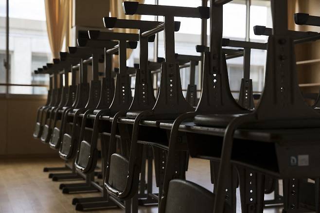 일본의 한 초등학교 교실. 학생들이 사용하던 책상과 의자가 가지런히 정리돼 있다. /사진=AFP