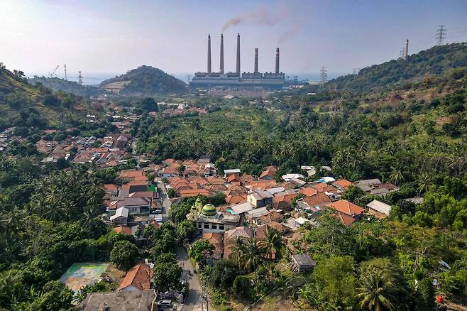 학계에서 기후변화에 대한 논란이 사실상 종결된 것으로 드러났다. 사진은 화석연료를 사용하는 공장과 인근 자연에 위치한 인도네시아의 마을 전경. [AFP]