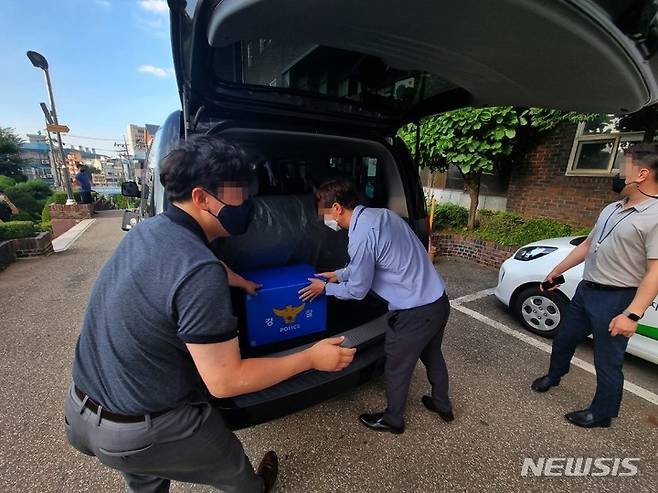 [인천=뉴시스] 김동영 기자 = 3일 오후 이강호 인천 남동구청장의 뇌물수수 의혹과 관련해 뇌물을 공여한 의혹을 받는 교감이 재직중인 인천 한 중·고등학교에서 인천경찰청 광역수사대 수사관들이 압수수색을 마친 뒤 압수품을 들고 나오고 있다. 2021.09.03. dy0121@newsis.com