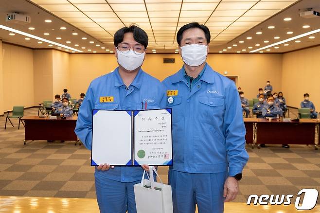 포스코 광양제철소 김지용 소장(오른쪽)이  '2021엔지니어 기술 컨퍼런스'에서 최우수상을 수상한 선강설비부 전한철 사원을 격려하고 있다(광양제철소 제공)2021.10.21/© 뉴스1
