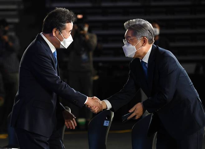 10일 오후 서울 송파구 SK올림픽핸드볼경기장에서 열린 더불어민주당 제20대 대통령선거 후보자 선출을 위한 서울 합동연설회에서 이낙연 후보(왼쪽)가 이재명 후보와 악수하고 있다. /뉴시스