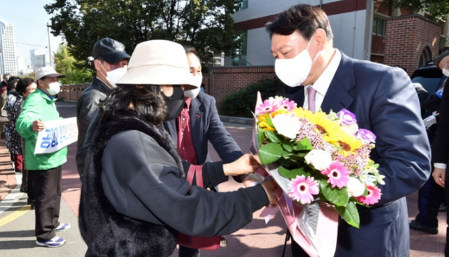 윤석열 국민의힘 대선 경선 후보가 20일 오전 대구 중구 천주교 대구 대교구청을 방문해 지지자에게 꽃다발을 받고 있다. ⓒ대구=뉴시스