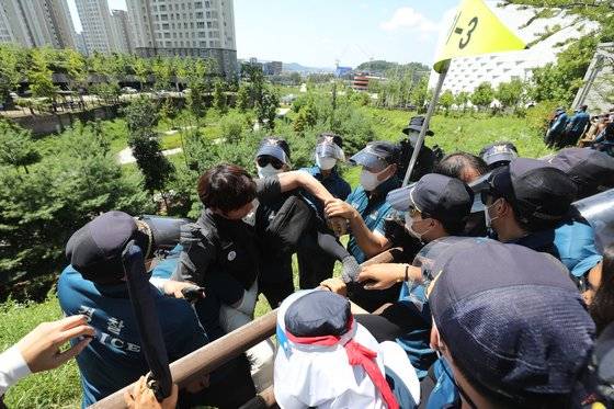7월 강원 원주시 건강보험공단본부 주변에서 경찰이 콜센터 직고용 요구 집회 장소로 접근하는 노조원을 막아서고 있다. 뉴스1
