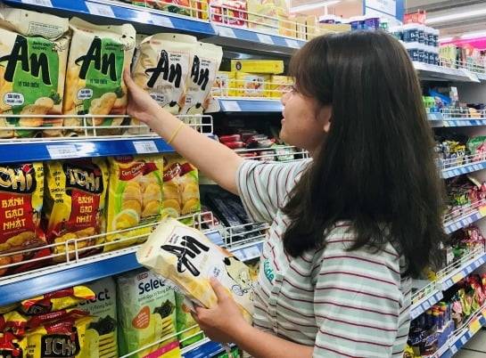 베트남 현지 소비자가 진열대에서 쌀과자 '안'을 고르는 모습. / 사진=오리온 제공