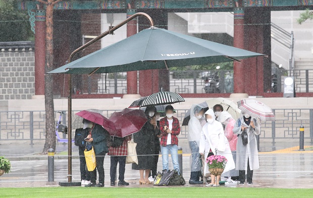 15일은 전국이 대체로 흐린 가운데 동해안을 중심으로 비가 내리겠다. 사진은 전국 대부분 지역에 비가 내린 지난 10일 오후 서울 시내에서 시민들이 그늘막 밑에서 비를 피하는 모습. /사진=뉴스1