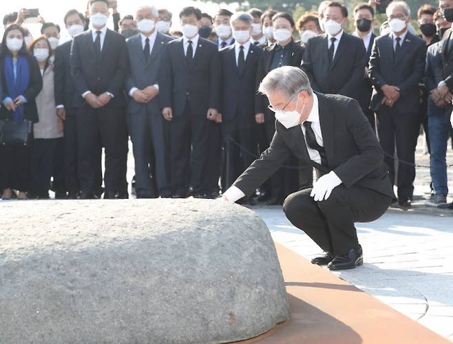 더불어민주당 대선 후보인 이재명 경기도지사가 22일 오후 경남 김해시 진영읍 봉하마을 노무현 전 대통령 묘역을 참배하며 앉아 너럭바위를 만지고 있다. (사진= 연합뉴스)