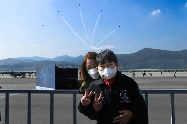 공군 특수비행팀 블랙이글스가 22일 ‘서울ADEX 2021’이 진행 중인 경기도 성남 서울공항에서 희귀 소아암으로 투병 중인 최윤수 군을 위한 특별 이벤트를 마련했다. 사진은 블랙이글스 에어쇼를 관람하는 도중 어머니와 기념 촬영하는 최윤수 군의 모습(사진=공군 제공).
