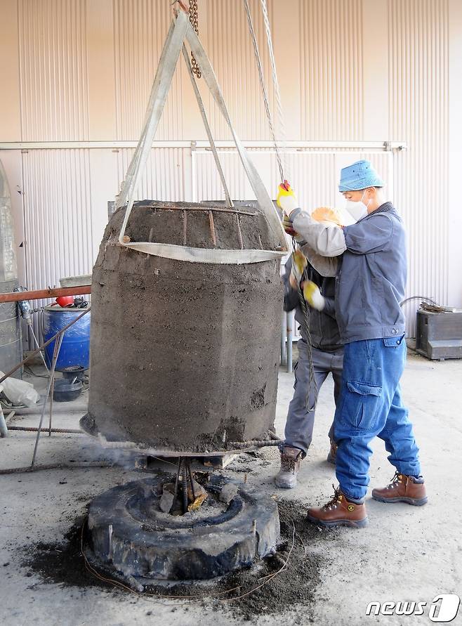 범종을 만들기 위한 시연회에서 전수자들이 거푸짚을 들어올리고 있다.2021.10.22© 뉴스1