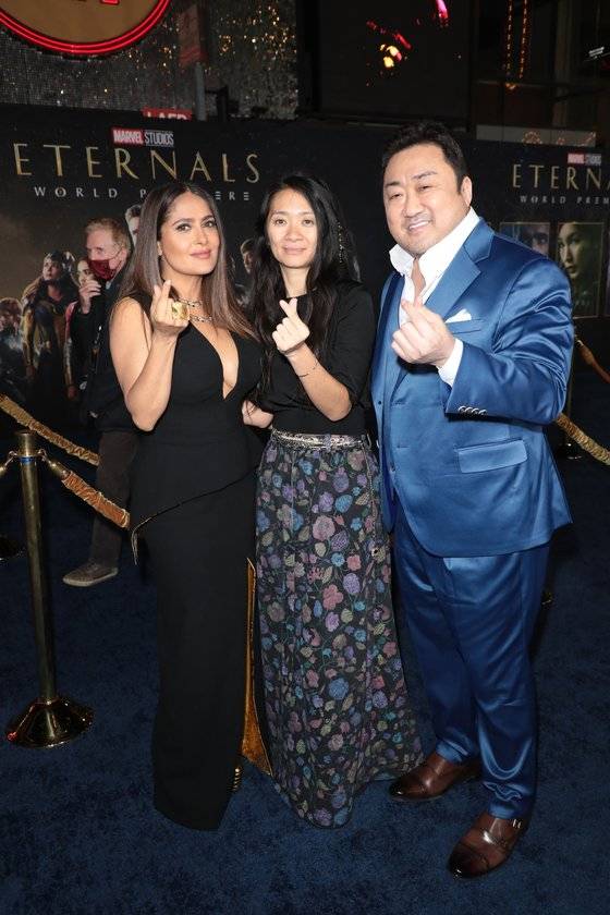 지난 18일(현지 기준) LA에서 열린 '이터널스' 월드 프리미어 행사에서 마동석(맨 오른쪽부터)이 클로이 자오 감독, 동료 배우 셀마 헤이엑과 함께 한국식 손하트 포즈를 취했다. [사진 월트디즈니컴퍼니 코리아]