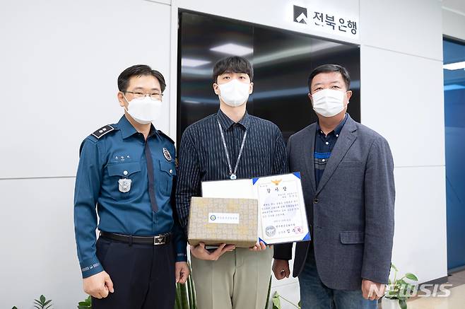 [전주=뉴시스]윤난슬 기자 = JB금융그룹 전북은행은 전주시 경원동 지점에 근무 중인 정영웅 대리가 전화금융사기(보이스피싱) 피해 예방 및 중간책 검거에 결정적인 역할을 한 공로를 인정받아 전주완산경찰서로부터 감사장을 받았다고 22일 밝혔다.(사진=전북은행 제공)