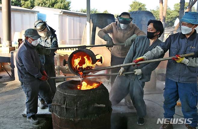 [진천=뉴시스] 강신욱 기자 = 국가무형문화재 112호 원광식 주철장이 22일 충북 진천군 덕산읍 성종사에서 전통밀랍주조기법으로 범종 제작과정을 공개시연한 가운데 작업자들이 쇳물을 거푸집에 붓고 있다. 2021.10.22. ksw64@newsis.com