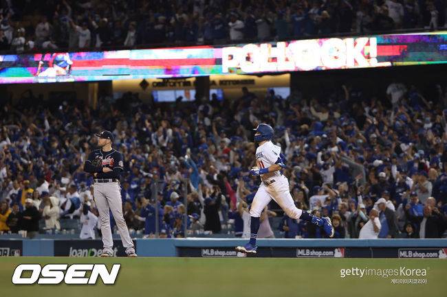 [사진] LA 다저스의 AJ 폴락(오른쪽)이 22일(한국시간) 다저스타디움에서 벌어진 애틀랜타와의 NLCS 5차전 8회서 승부의 쐐기를 박는 3점 홈런을 친 뒤 관중들의 환호성을 받으며 1루 베이스를 돌고 있다. ⓒGettyimages(무단전재 및 재배포 금지)