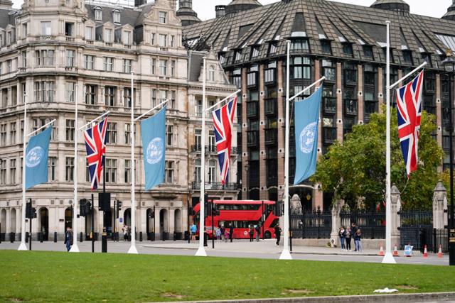 지난 24일 영국 런던 의회광장 앞에 영국 국기와 유엔 깃발이 걸려 있다. 다음 달 1~2일 영국 글래스고에서 26차 유엔기후변화협약당사국총회(COP26) 정상회의가 열릴 예정이다. 런던=AP 연합뉴스