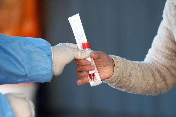 코로나19 신규확진 1190명 - 25일 서울역 광장에 마련된 신종 코로나바이러스 감염증(코로나19) 임시 선별검사소에서 의료진이 검체 키트를 건네고 있다. 2021.10.25 연합뉴스