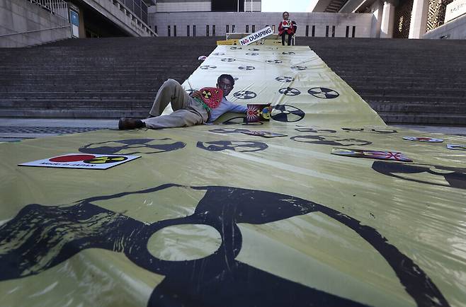 On the stairs of the Sejong Center in central Seoul on Monday, members of the Asian Citizen’s Center for Environment and Health and the Korea Federation for Environmental Movements’ committee on ocean protection stage a protest of Japan’s plans to dump contaminated water from the Fukushima Daiichi nuclear power plant into the ocean. (Yoon Woon-sik/The Hankyoreh)