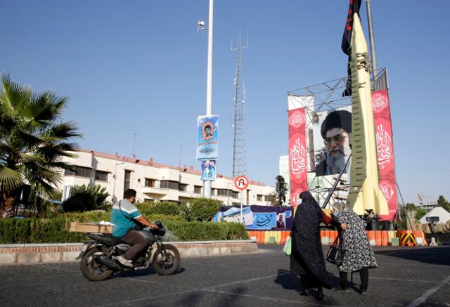 지난달 25일 이란 테헤란 바하레스탄 광장에 최고지도자 아야톨라 세예드 알리 하메네이의 사진과 함께 중장거리 탄도 미사일인 샤하브-3이 전시돼 있다. 테헤란=EPA 연합뉴스