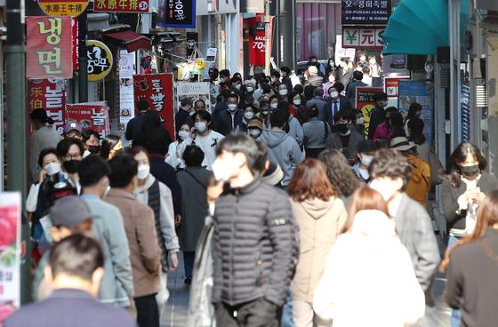 People crowd a street in Myeong-dong, central Seoul, on Monday ahead of the government's ″With Corona″ scheme, which is expected to be introduced at the beginning of November. [YONHAP]