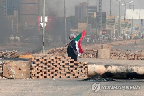 하르툼 시내 주요 도로에 세워진 바리케이드 반쿠데타 시위대가 수단 수도 하르툼 시내 주요 도로에 바리케이드를 세운 가운데 한 남성이 국기를 들고 서 있다.
[AFP 연합뉴스. 재판매 및 DB 금지]