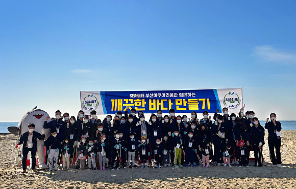 26일 해운대 해수욕장에서 열린 '깨끗한 바다 만들기' 행사에서 씨라이프 부산 아쿠아리움 직원과 고객들이 바다정화 활동을 한 뒤 기념사진을 찍고 있다.  [사진=씨라이프부산아쿠아리움]