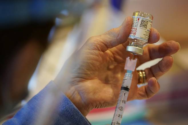 미국 보건부 직원이 지난 25일(현지시간) 펜실베니아주 체스터 정부 서비스센터에서 코로나19 백신을 주사기에 옮겨담고 있다. 체스터|AP연합뉴스