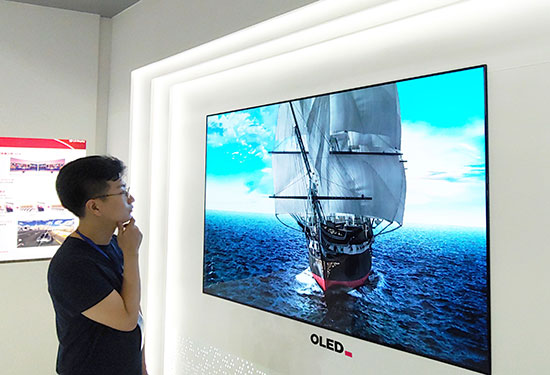LG디스플레이 직원이 유기발광다이오드(OLED) TV 패널을 보고 있다. (LG디스플레이 제공)