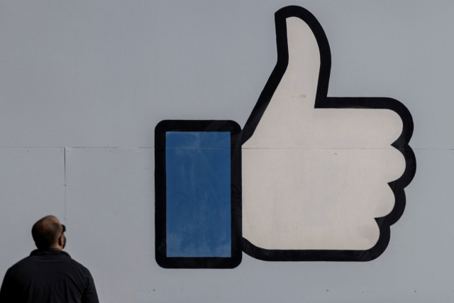 27일(현지 시간) 미국 캘리포니아 먼로 파크에 있는 페이스북 본사의 ‘좋아요’ 로고를 한 직원이 쳐다보고 있다. /로이터연합뉴스