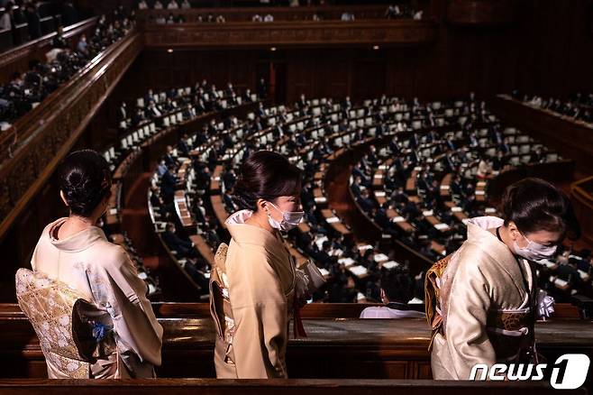 기시다 후미오 신임 일본 총리가 11일 중의원에서 연설하는 장면을 전통의상 차림의 여성들이 지켜보고 있다. © AFP=뉴스1