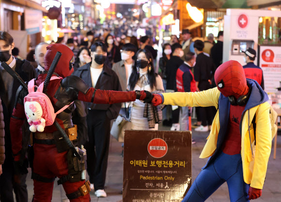 ‘핼러윈을 즐기자’ - 주말 핼러윈을 앞둔 29일 오후 서울 용산구 이태원 세계음식거리를 찾은 시민들이 영화 캐릭터 복장을 입고 기념촬영을 하고 있다. 2021.10.29 연합뉴스