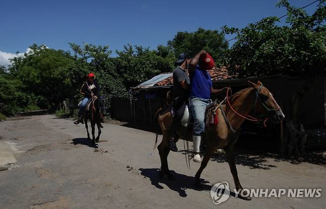 26일(현지시간) 말을 타고 온두라스에 백신 맞으러 가는 니카라과인들  [로이터 연합뉴스 자료사진. 재판매 및 DB 금지]