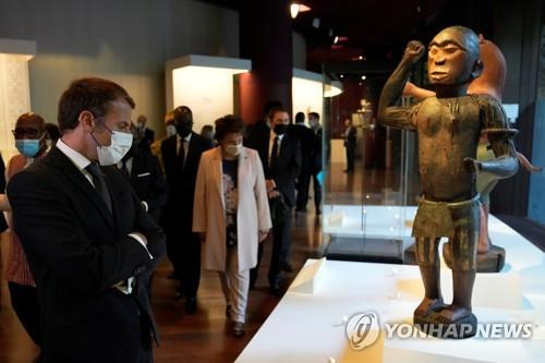 반은 사람, 반은 새 (파리 풀사진·로이터=연합뉴스) 27일(현지시각) 마크롱 프랑스 대통령이 파리의 케 브랑리 박물관에서 19세기 게조 국왕의 반은 사람이고 반은 새인 왕실 조각을 보고 있다. 2021.10.29 photo@yna.co.kr