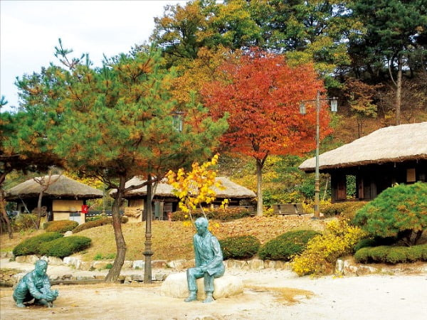 강원 춘천 김유정문학촌의 가을 풍경과 ‘동백꽃’의 수탉 싸움 장면을 재현한 조형물.  /김유정문학촌 제공