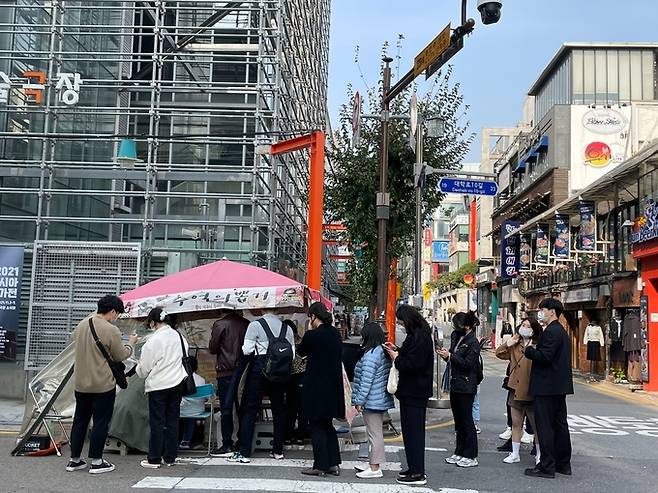 지난 26일 서울 종로구 혜화동 ‘추억의 뽑기 달고나 노점’ 앞에 인파가 줄을 선 기다리고 있다. 전북 전주, 부산 등 전국에서 손님들이 온다고 노점 주인은 귀띔했다.