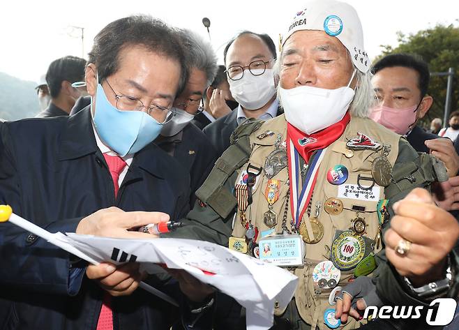 국민의힘 대선 경선 후보 홍준표 의원이 1일 오후 자신의 지역구인 대구 수성못 상화동산을 찾아 시민의 요청에 사인을 해주고 있다. 2021.11.1/뉴스1 © News1 공정식 기자