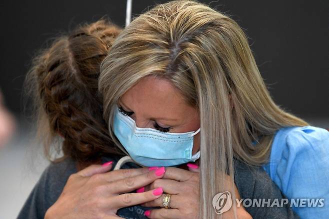 '아이야, 그동안 잘 지냈지?' (시드니 AFP=연합뉴스) 엄마가 시드니 공항에서 내린 뒤 코로나19로 보지 못했던 아이를 꼭 껴안고 있다. 2021. 11. 1 photo@yna.co.kr