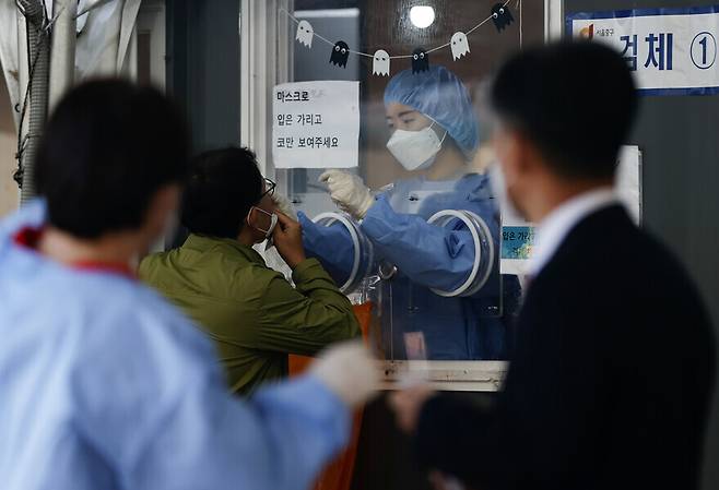 A person gets tested for COVID-19 on Monday at a temporary screening center set up in the plaza outside of Seoul Station. (Yonhap News)