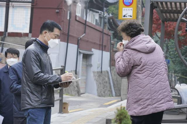 이승로(왼쪽) 서울 성북구청장이 지난달 27일 ‘온라인 현장 구청장실’ 오픈을 앞두고 구청 직원들과 함께 정릉동 현장을 살펴보던 도중 한 주민의 이야기를 듣고 있다.성북구 제공