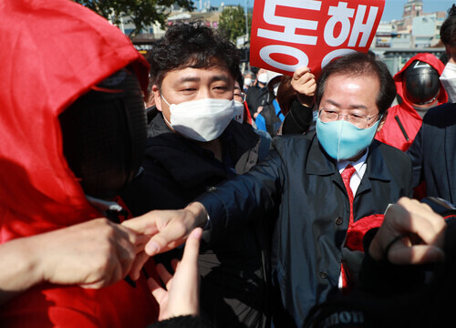 Rep. Hong Joon-pyo, a candidate in the PPP presidential primary, greets supporters on Tuesday following a press conference at Busan Station. (Yonhap News)