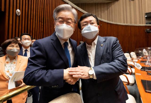 더불어민주당 이재명 대선후보(왼쪽)가 지난 15일 오전 서울 국회에서 열린 더불어민주당 의원총회에서 이낙연 캠프 공동선대위원장이었던 설훈 의원과 인사하고 있다. /연합뉴스