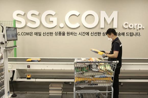 SSG닷컴은 전국 각지의 이마트 매장을 PP(Picking&Packing)센터로 탈바꿈해 전국 단위 배송망을 갖추겠다는 목표다. 이마트 이천점 PP센터에서 작업자가 자동화 소터에 상품을 투입하고 있다. [사진=SSG닷컴]