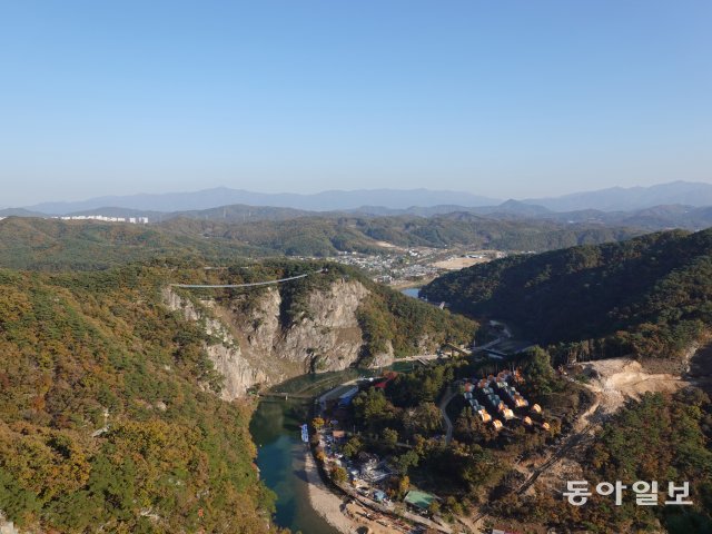 잔도에서 바라본 소금산 그랜드밸리. 삼산천을 가운데 두고 왼쪽의 두 절벽 사이를 잇는 다리가 출렁다리이고 그 밑으로 자연암벽을 스크린으로 삼아 공연을 하는 미디어파사드 공연장이 있다. 삼산천 오른쪽으로는 글램핑장이 보인다.