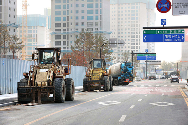 Construction equipment that need urea water solution for operations are parked at a construction site in Goyang, Gyeonggi Province, on Thursday. Urea water solution is essential in reducing diesel engine pollutants. Excavators and concrete mixers use diesel engines. [Photo by Han Joo-hyung]