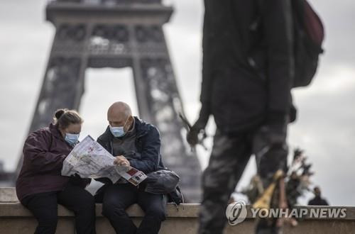 프랑스 파리 에펠탑을 배경으로 지도를 보고있는 관광객들 [EPA=연합뉴스. 재판매 및 DB 금지]