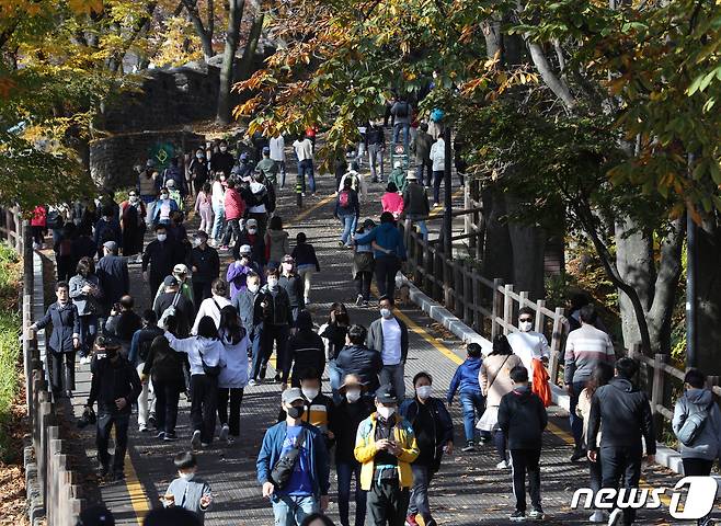 단계적 일상회복(위드 코로나) 시행 후 첫 주말인 7일 서울 남산을 찾은 시민들이 가을을 만끽하고 있다. 서울의 경우 이날 낮 최고기온이 21도 안팎까지 오르며 30년 만에 가장 포근한 입동을 기록했으며 내일은 전국적으로 비가 내리며 추워질 예정이다. 2021.11.7/뉴스1 © News1 신웅수 기자