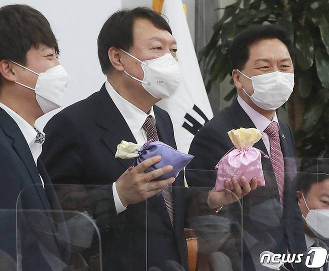 윤석열 국민의힘 대선후보(왼쪽 두 번째)가 8일 오전 서울 여의도 국회에서 열린 최고위원회의에서 이준석 대표에게 비단주머니를 받은 후 발언하고 있다. 2021.11.8/뉴스1 © News1 이동해 기자