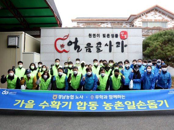 무학과 경남농협 임직원들로 구성된 봉사단이 10일 밀양 산내면 일대 농촌 일손돕기 봉사활동에 나서면서 기념촬영을 하고 있다. 무학 제공