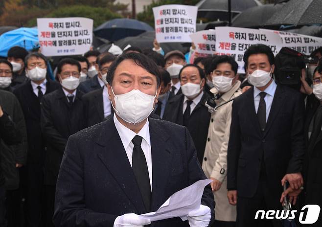 (광주=뉴스1) 이동해 기자 = 윤석열 국민의힘 대선 후보가 10일 광주 북구 국립 5·18 민주묘지에서 방문을 항의하는 시민들에게 막혀 참배단까지 가지 못한 채 도중에 멈춰 서 사과문을 읽고 있다. 2021.11.10/뉴스1