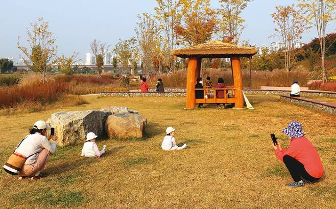 엄마와 아이들이 장미정원에서 사진을 찍으며 여가를 즐기고 있다.